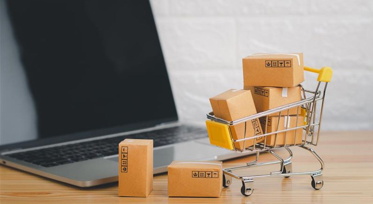 Picture of a computer beside a miniature shopping cart